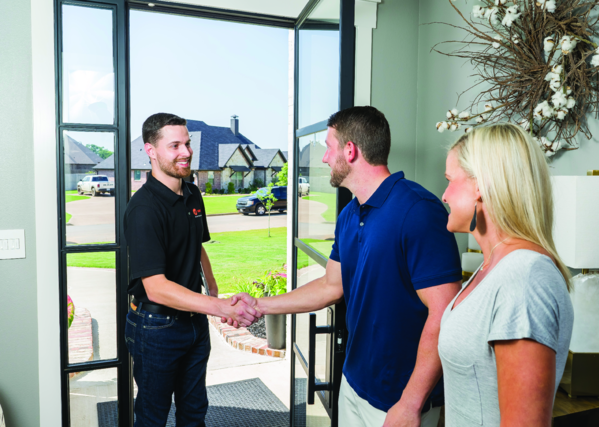 Texas Bree HVAC technician greeting a homeowner with a handshake at the front door